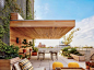 For the sprawling rooftop terrace of a Manhattan penthouse, Greg Dufner and Daniel Heighes Wismer of design firm Dufner Heighes devised a cantilevered mahogany awning and coordinating planters; the sconces are from YLighting, the tables and chairs are by 