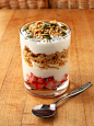 Coconut yogurt parfait (layered from bottom: chopped strawberries, coconut yogurt, sliced banana, granola, coconut yogurt, granola, chia seeds, and pumpkin seeds.)