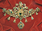 Stomacher brooch with emeralds and enamel flowers on gold, from the treasure of the Virgin of Pilar, mid-17th century; in the Victoria and Albert Museum, London.