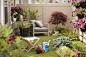 Soil and gardening tools sit amidst a wide selection of flowers and plants.