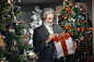 Elderly Man in Gray Coat Holding Christmas Gift Box 