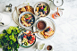 An overhead shot of a waffle, bowls of fruit oatmeal and a cup of coffee