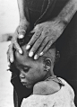 【干旱灾区的难民】
1974   饥饿者的脸孔。母亲在安抚自己的孩子，他们都是干旱的受害者。(Ovie Carter) 