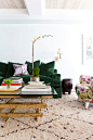 Eclectic mix of patterns and textiles with dark green velvet sofa: 