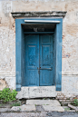 旧的木质蓝色门在旧建筑的墙壁上。