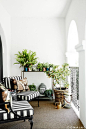 Reading nook on balcony with plants and striped furniture: 