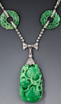 Art Deco Platinum and Diamond Carved Jade Necklace, Double-sided pendent of variegated apple green hues crowned with a platinum and diamond cap which, suspends from a stylized bow motif centering on a pair of French-cut diamonds held by two rows of sparkl