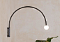 Contour Wall Lamp 22 是简单的拱形结构，由弯曲的金属制成，末端是一颗手工制作的玻璃灯球。