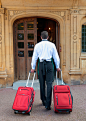 车轮,人,制服,户外,35岁到39岁_565878369_Caucasian butler wheeling luggage outside hotel_创意图片_Getty Images China