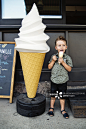 Little boy eating an ice cream cone outdoors._创意图片