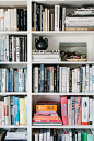 white built-in bookcase with color blocked books. / sfgirlbybay