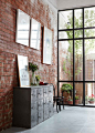 Floor to ceiling windows and exposed brick.