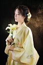 woman in yellow robe holding white flowers