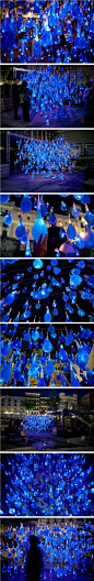 西班牙的一个艺术组合Luzinterruptus 日前在马德里展出一件装置艺术，这件作品非常独特，制作材料是800只避孕套，里面装满蓝色的水，和一个发光体。将其全部进行组合，悬挂起来，形状如同正在下落的雨滴。（我们都是蓝色控@蓝色潮流控）