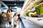 Mother and daughter pushing shopping carts in store by Hero Images on 500px