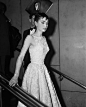 At the 26th Annual Academy Awards, Audrey Hepburn wore a white floral, belted dress designed by couturier Hubert de Givenchy.  It was also the first time audiences saw Audrey wearing a Givenchy gown but definitely not the last.  The actress and couturier 