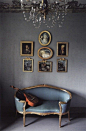 a lovely vignette - gallery wall, vintage seat, chandelier...