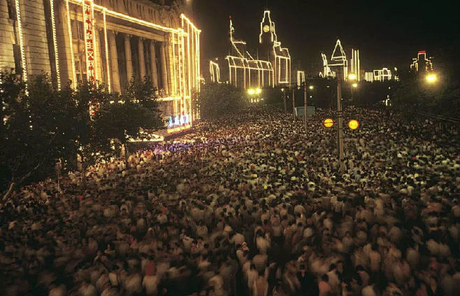 1983年，中国上海市，夜晚灯光下拥挤的...