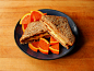 Almond butter and apple sandwich on sprouted whole grain bread and a Cara Cara orange.