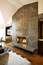 Glass tile and metal panels combine to create an eye-catching fireplace fixture.: 