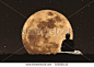 Silhouette a man sitting relaxing under full moon at night with stars on the sky