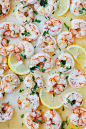 Garlic butter shrimp served with lemon wedges.