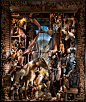 In the final window, “Artists and Models,” a diverse collection of wood and leather folk-art animals from all continents gathers together.  The setting is a sculptor’s studio out of a folk tale, with an enormous assemblage of wooden creatures.  A mannequi