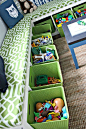 Two tall skinny bookcases on their sides with fabric bins and custom cushions.