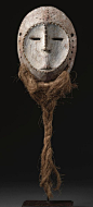 A LEGA MASK, DEMOCRATIC REPUBLIC OF THE CONGO  of oval form, and pierced around the rim for the attachment of a fiber beard, with concave heart shaped facial plane, slit mouth and raised linear nose flanked by pierced slit eyes; aged patina with traces of