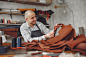 Man in a studio creates leather ware Free Photo