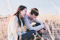 Woman in White Shirt Beside Man in Gray Long Sleeve Shirt Laughing during Daytime