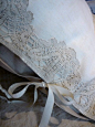 White linens with cream lace trim and ties.