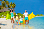 Happy beautiful family on white beach with inflatable air mattresses and toys by Dmitry Travnikov on 500px