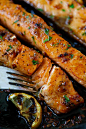 Honey salmon filets cooked with lemon and garlic flaked with fork in skillet