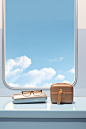a window with luggage and glasses, in the style of light sky-blue and light white, rich and immersive, expansive skies, highly polished surfaces, light white and light bronze, commercial imagery, clean and simple designs