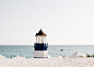 Photo of Blue and White Painted Lighthouse Near the Beach · Free Stock Photo