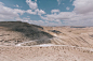 nature desert soil dirt dry ground bushes light shadows paths roads sky clouds horizon brown beige 