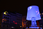 2014法国灯光艺术节台灯灯饰设计，该台灯样式的灯光设计是由广场中的一个喷水池扩展演变而来。非常搭配的创意设计，同时灯光也采用了投射技术将台灯罩投射出不同图案，看上去更为活泼。
