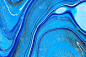 流体艺术纹理。抽象背景与混合油漆效果。液体丙烯酸图片与流动和飞溅。混合油漆背景或海报。海军蓝、金色和