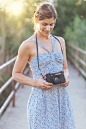 Smiling woman in dress using old camera.