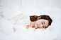 躺,仰卧,斜躺着,亚洲人,生活方式_gic11131764_a woman  in white sleeping in a bed with white sheets_创意图片_Getty Images China