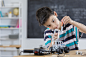 Handsome boy builds robot at school