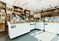 Wire-encased lights are suspended above oak-topped counters at this bakery in Poland by designer Maciej Kurkowski.