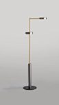 TWO CYLINDERS - Floor Lamp. This floor lamp is crafted from a brushed grey cylindrical base. It's two arms extend vertically above the base, branching in different directions. Both arms are connected to the central pole via cylindrical joints. The shades 