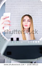 Young and beautiful woman taking selfie picture with mobile phone in light of the ring lamp