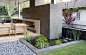 This small pond beside an outdoor lounge and fireplace adds a relaxing touch to the backyard and incorporates water dwelling plants to create a small water garden.