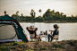 年轻的背包客夫妇坐在靠近湖边的帐篷前放松的后视图，带着咖啡具，在暑假露营时制作新鲜的咖啡研磨机 免费照片