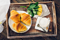 Coffee, croissant and flowers on tray on a wooden table by Kamil Zabłocki on 500px