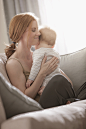 Caucasian mother sitting on sofa holding son : Caucasian mother sitting on sofa holding son