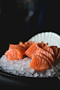 餐厅里，新鲜的生三文鱼放在黑色盘子里，配上冰块。图片下载